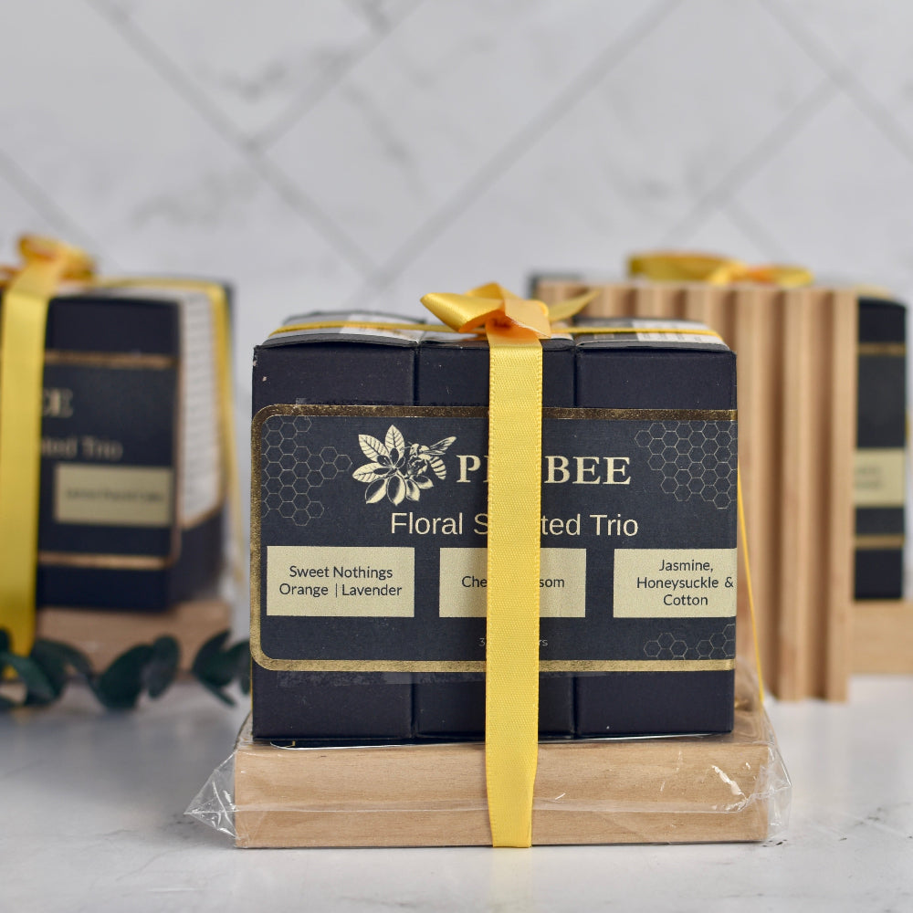 Three bars of soap in a black box with a yellow ribbon, branded &
