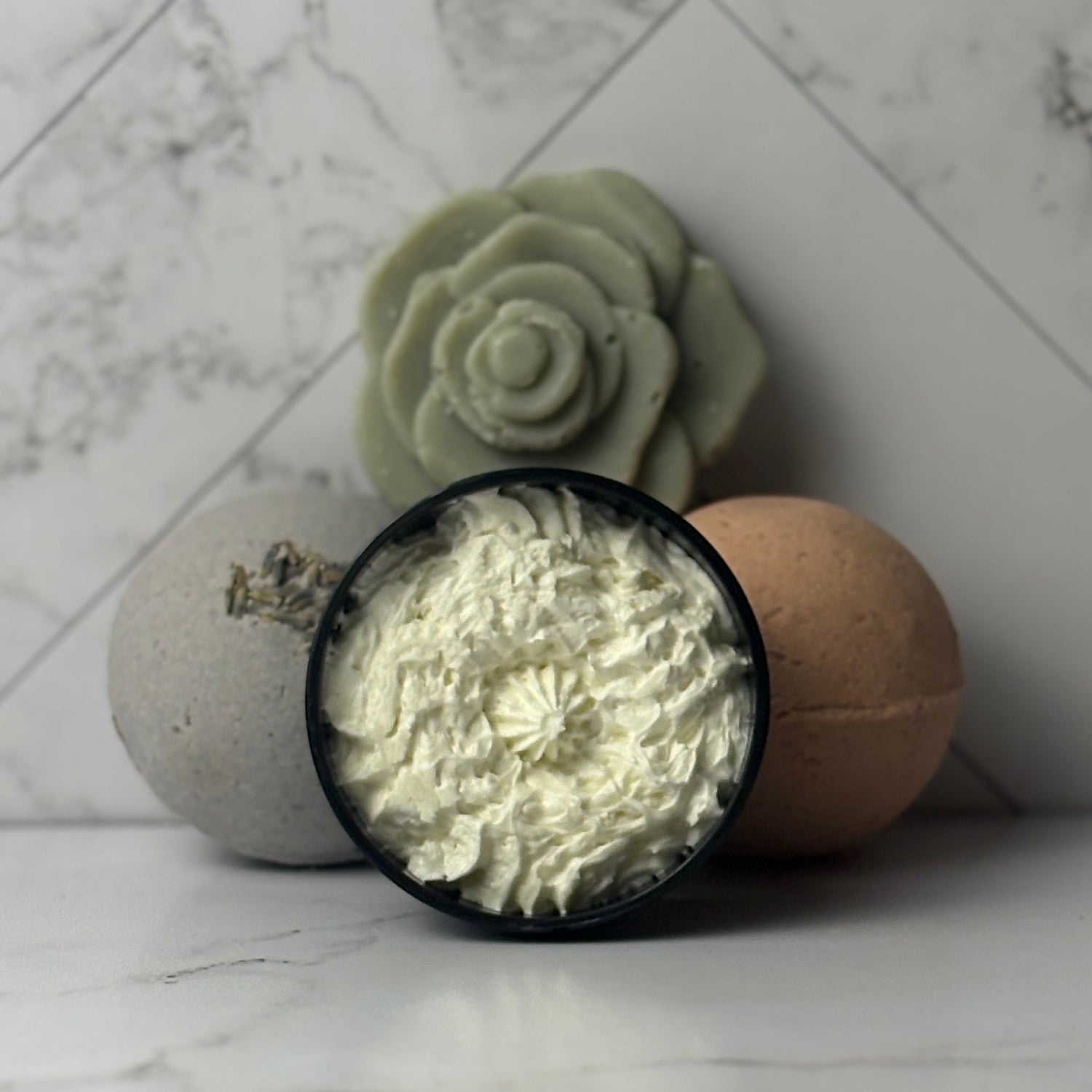 Bath bomb with wooden top and floral soap on marble surface
